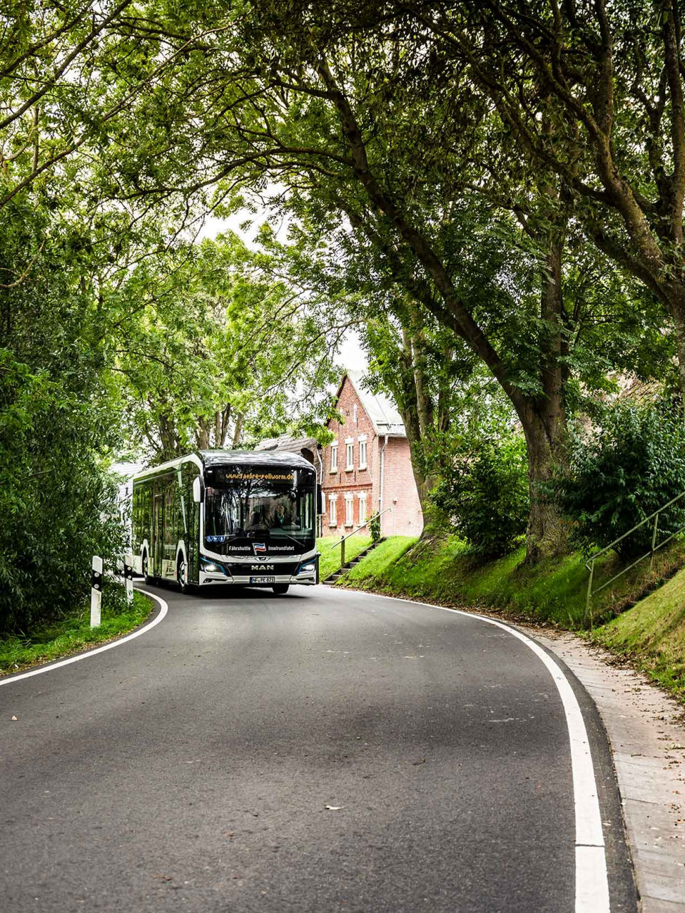 MAN Lion's City E among rural streets