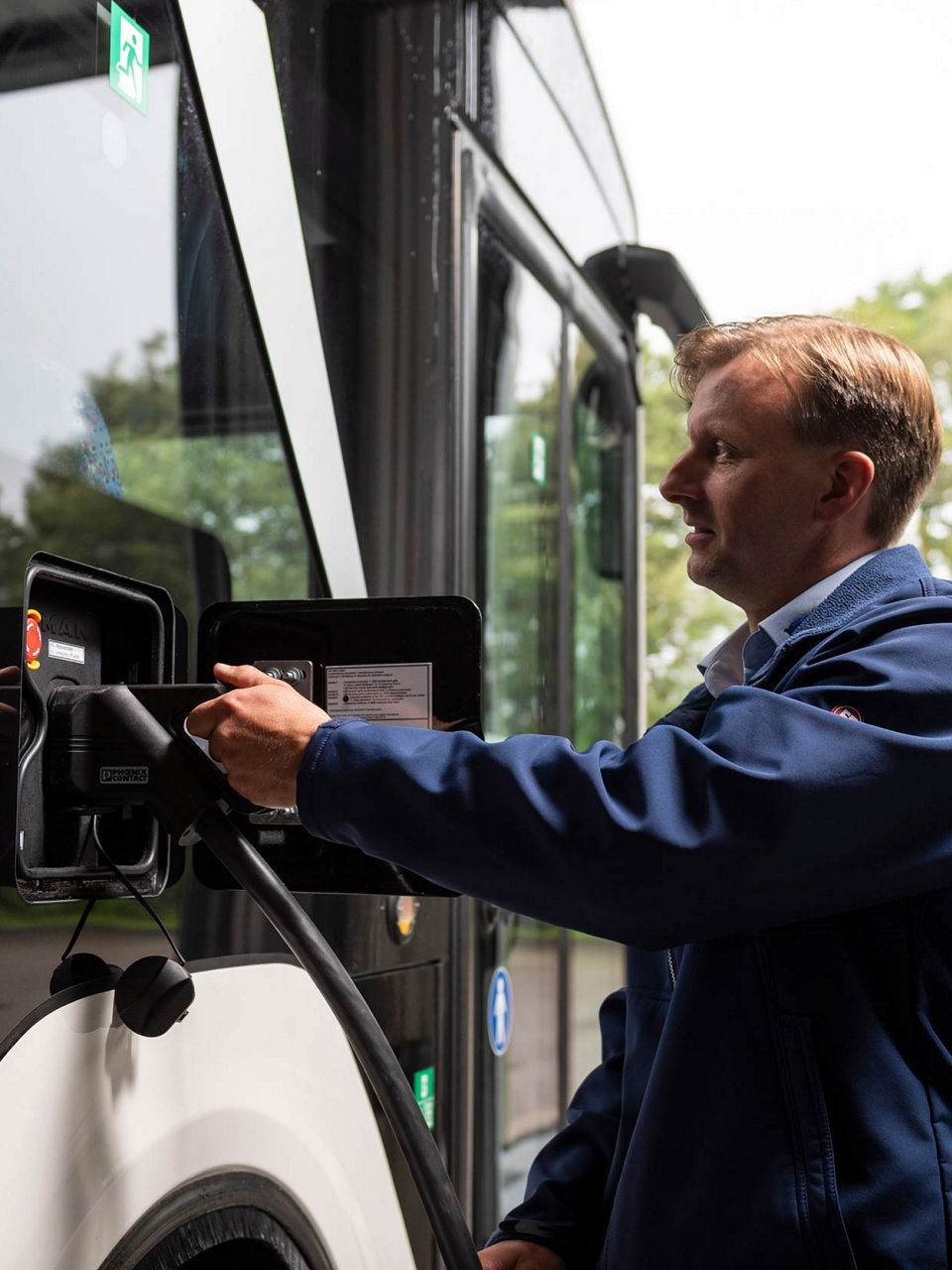 MAN employee plugging in the charging cable