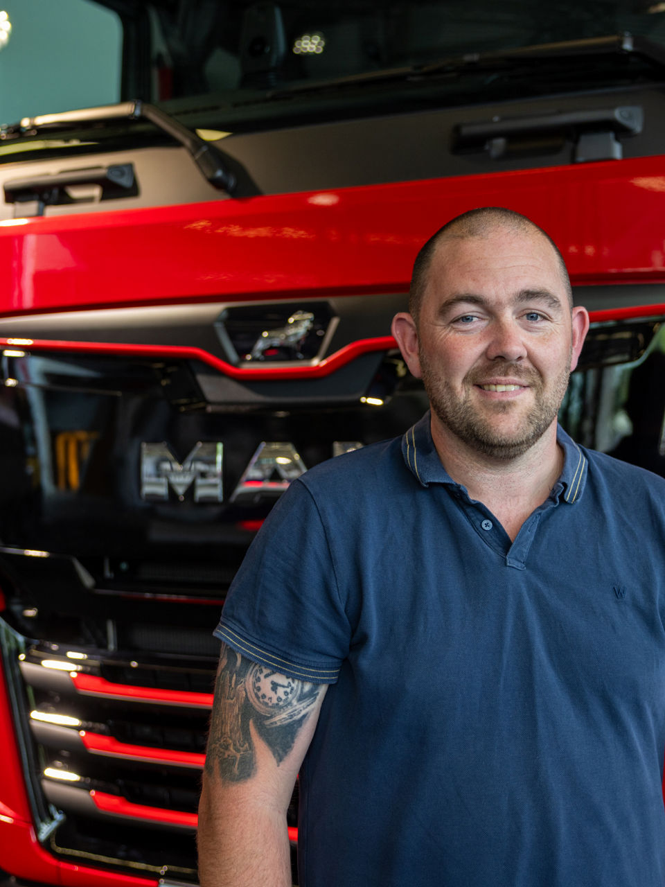A man standing in front of a red truck