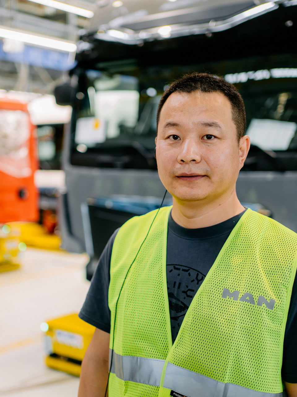 Ein Mann in einer Warnweste steht vor einem weißen Lkw