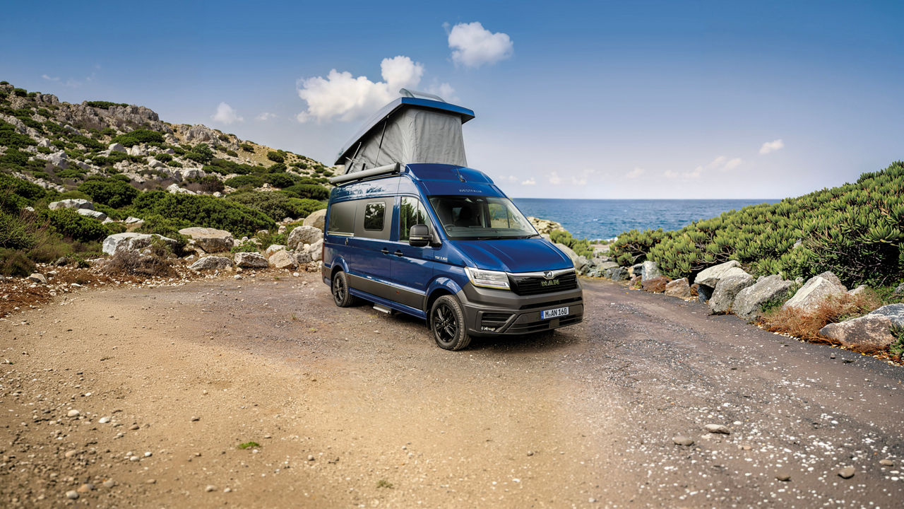 Blauer Westfalia Sven Hedin auf MAN TGE Basis mit geöffnetem Aufstelldach.