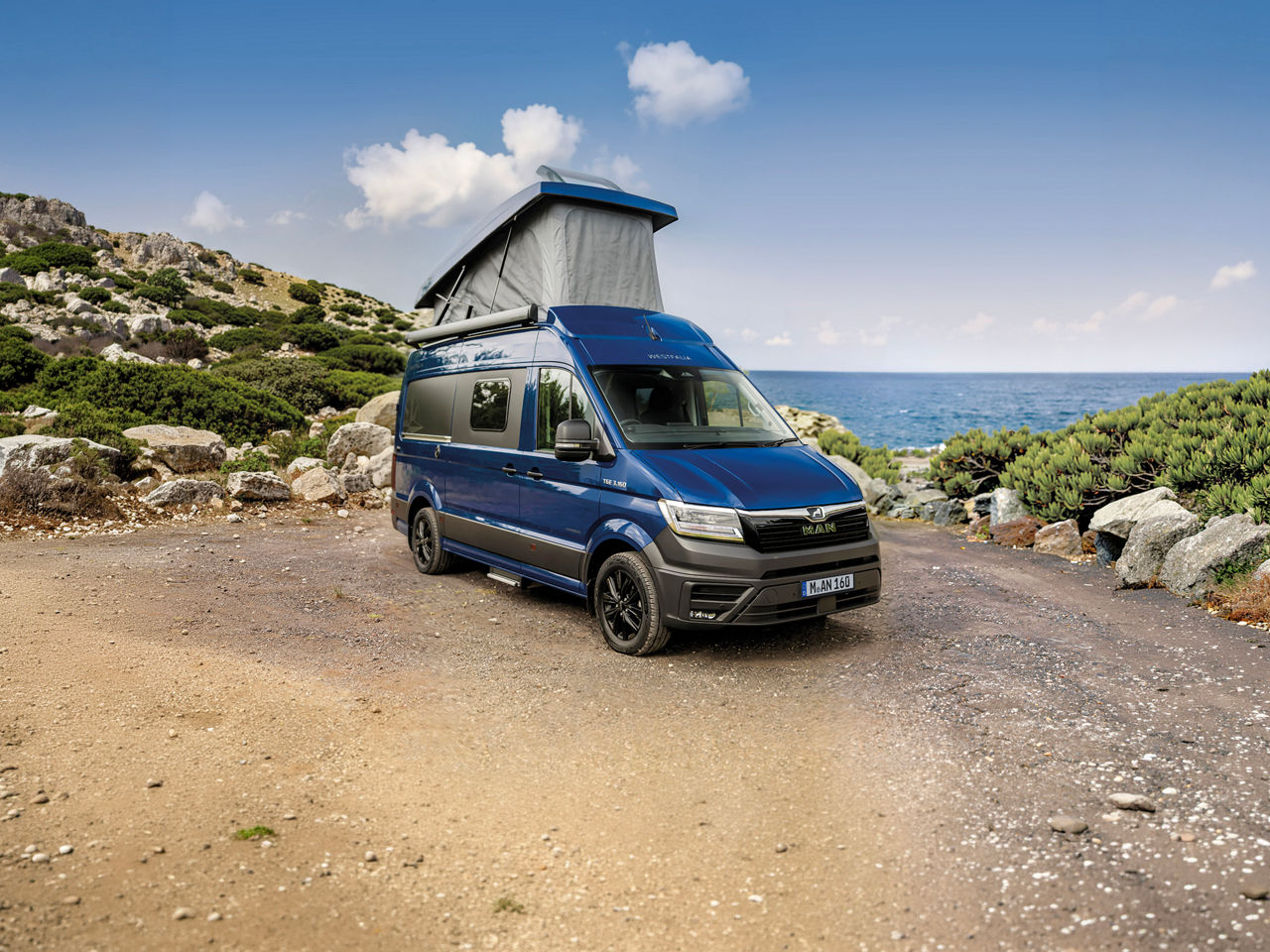 Blauer Westfalia Sven Hedin auf MAN TGE Basis mit geöffnetem Aufstelldach.