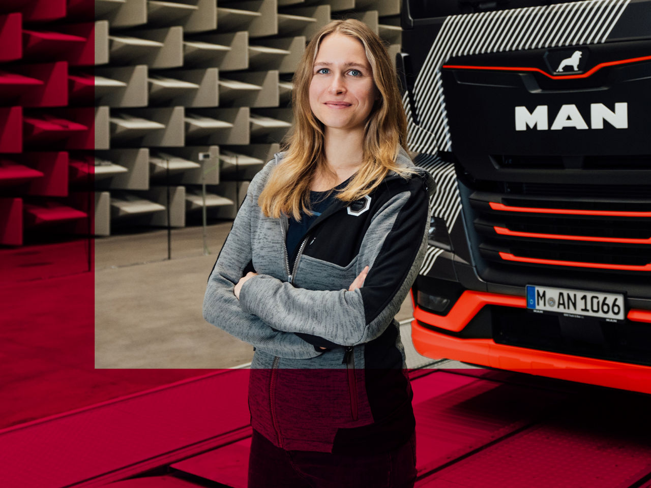A smiling woman is standing in front of a truck