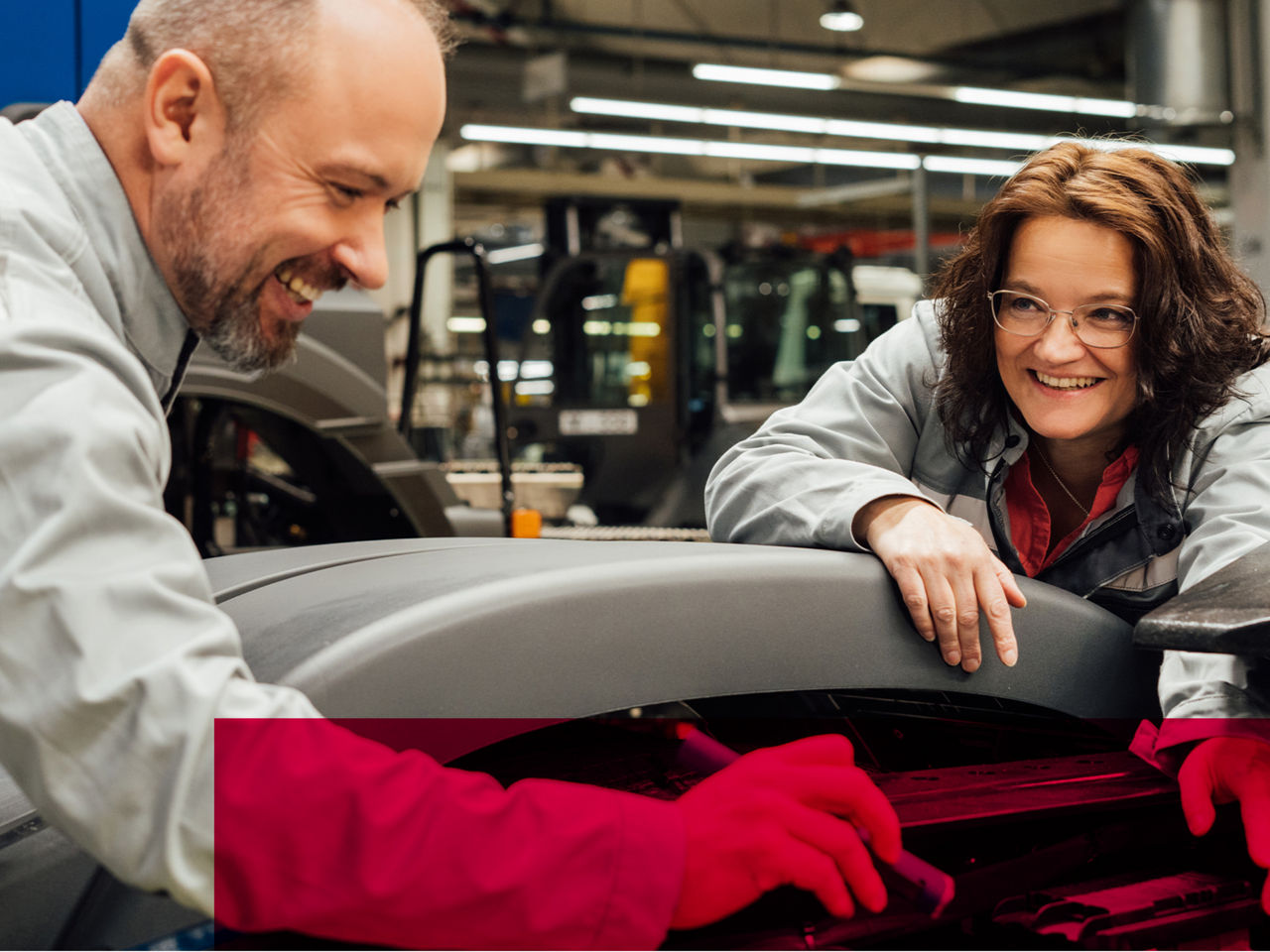 A man and a woman are working on an object together.