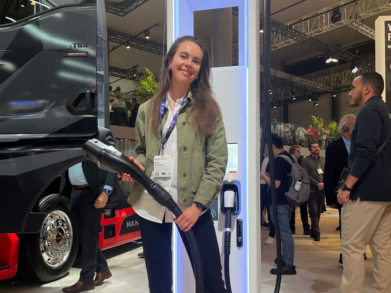 Eine Frau steht an einer Elektro-Ladesäule 