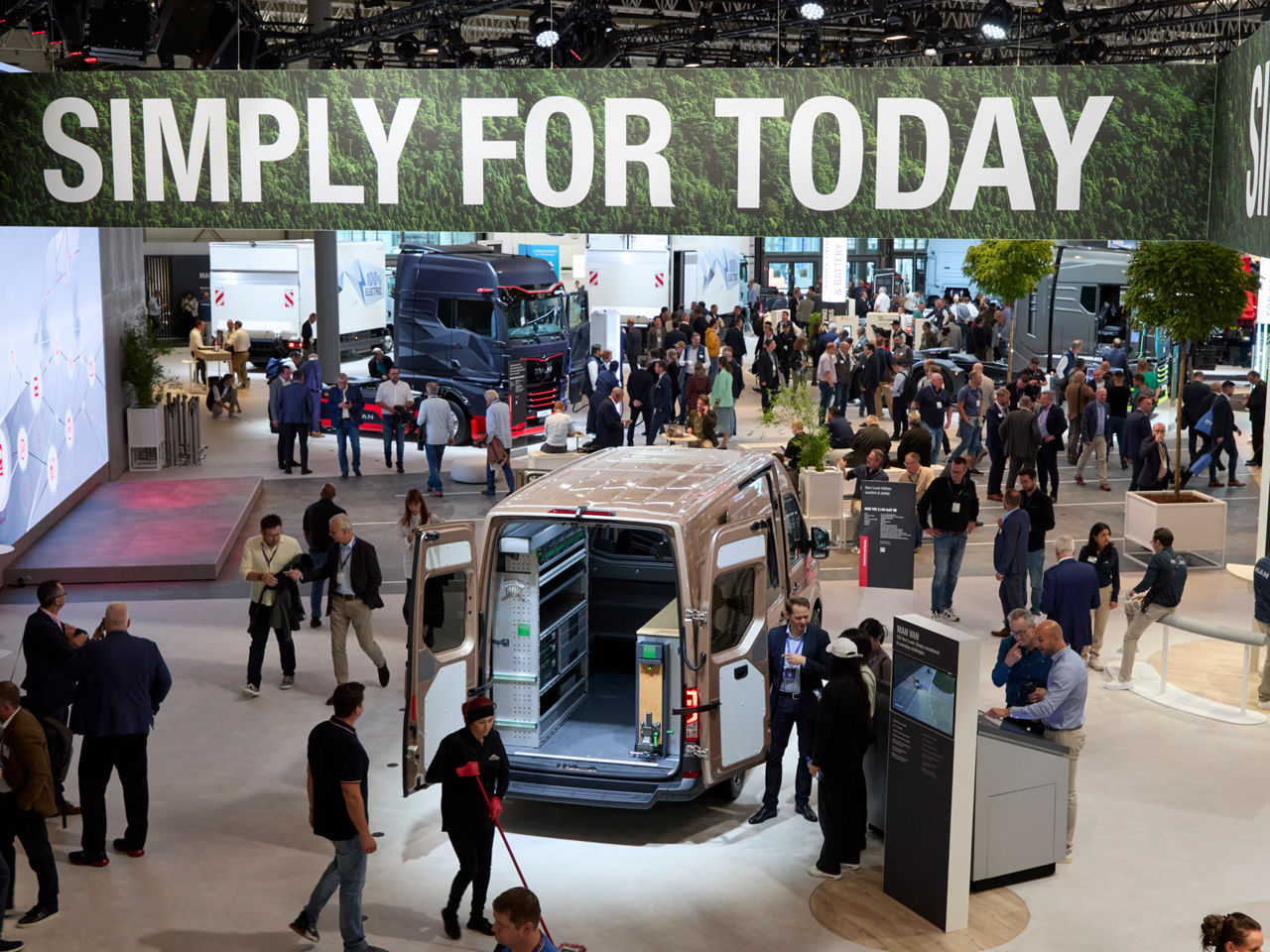 Eine Messehalle mit einem Transporter und einem Banner mit der Aufschrift "Simply for today"