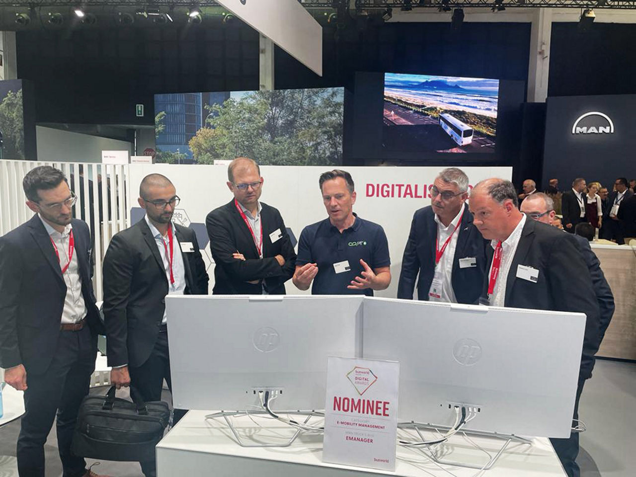 MAN experts and CO2OPT employees talking in front of two monitors at Bussworld