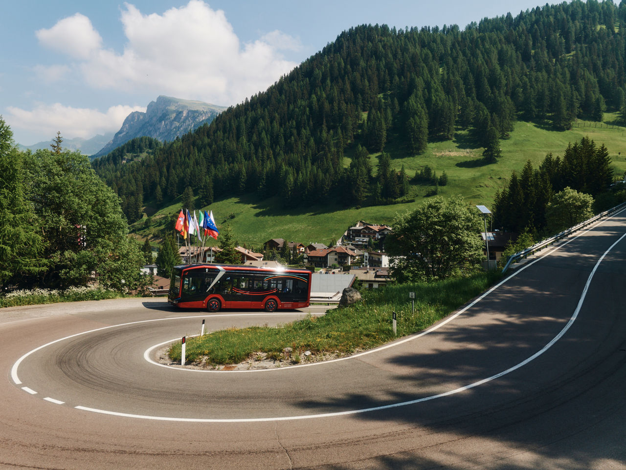 The MAN Lion's City E 10 drives through winding roads in the mountains