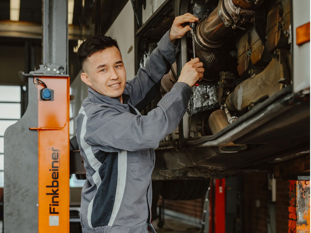 Eine junge Frau arbeitet an einer Lkw-Karrosserie