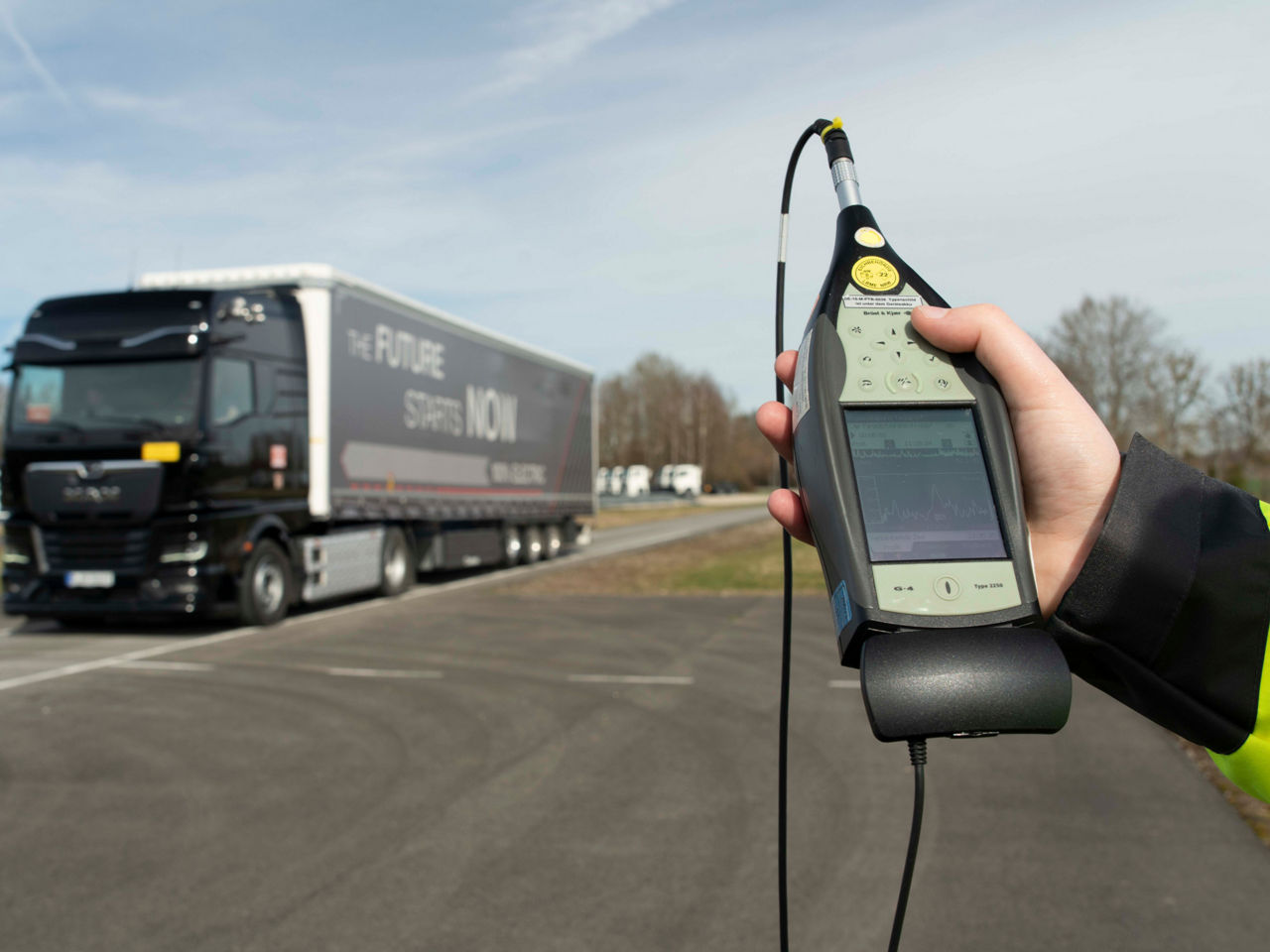 Eine Hand hält ein Messgerät für Geräusche