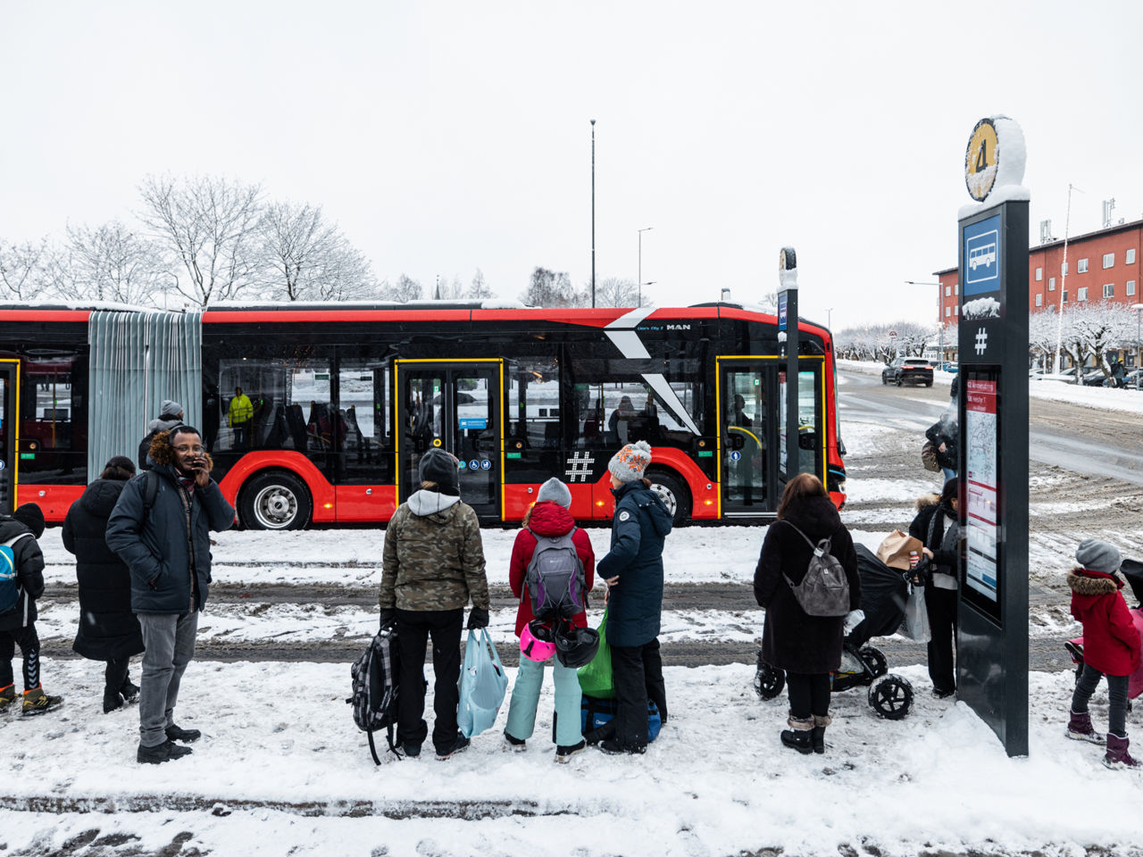 Ein roter MAN Lion's City 18 E wartet an einer Osloer Bushaltestelle auf Fahrgäste.