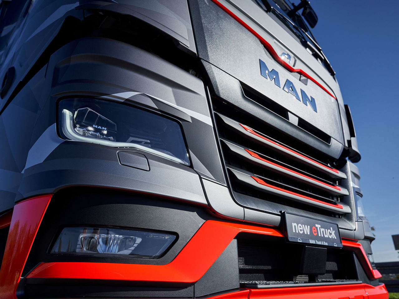 Close-up of MAN electric truck eTGX front with red design accents
