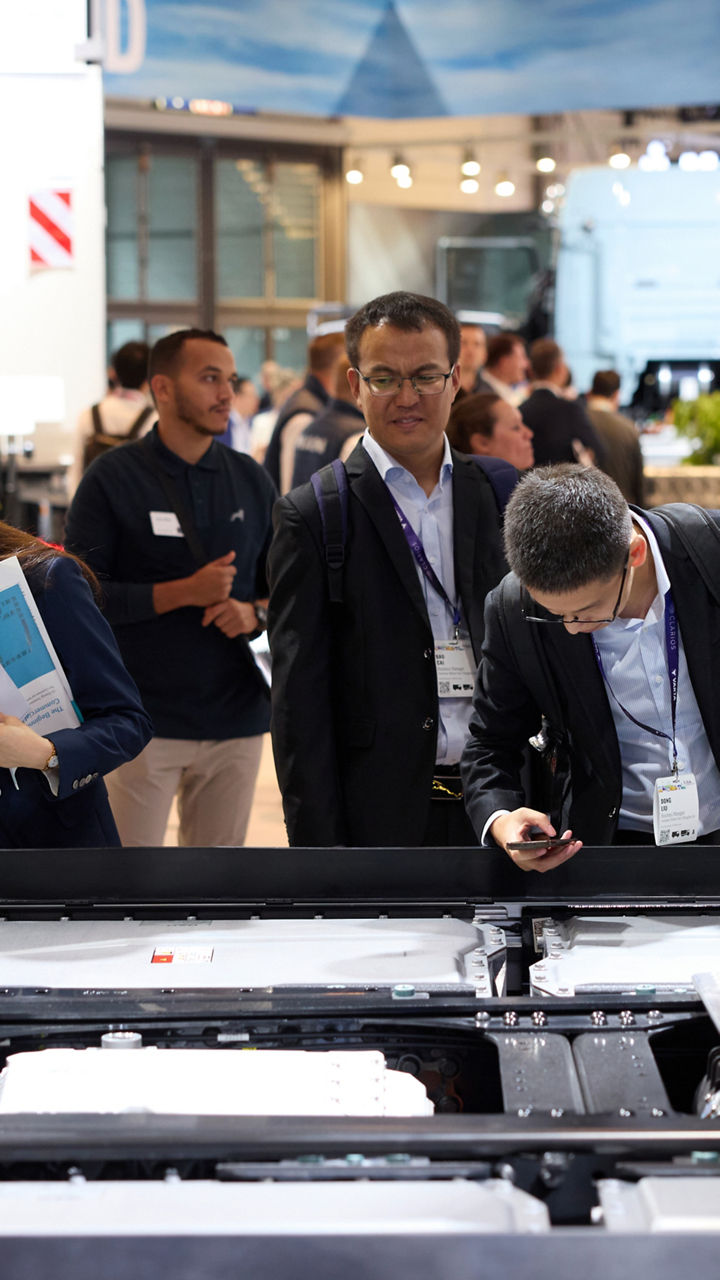 Eine Gruppe Asiaten beugt sich über das Innere eines Lkw