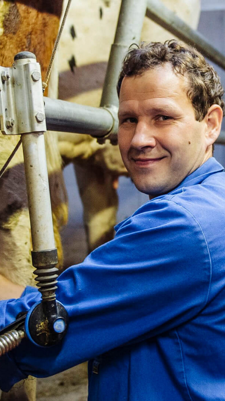 Almbesitzer melkt eine Kuh