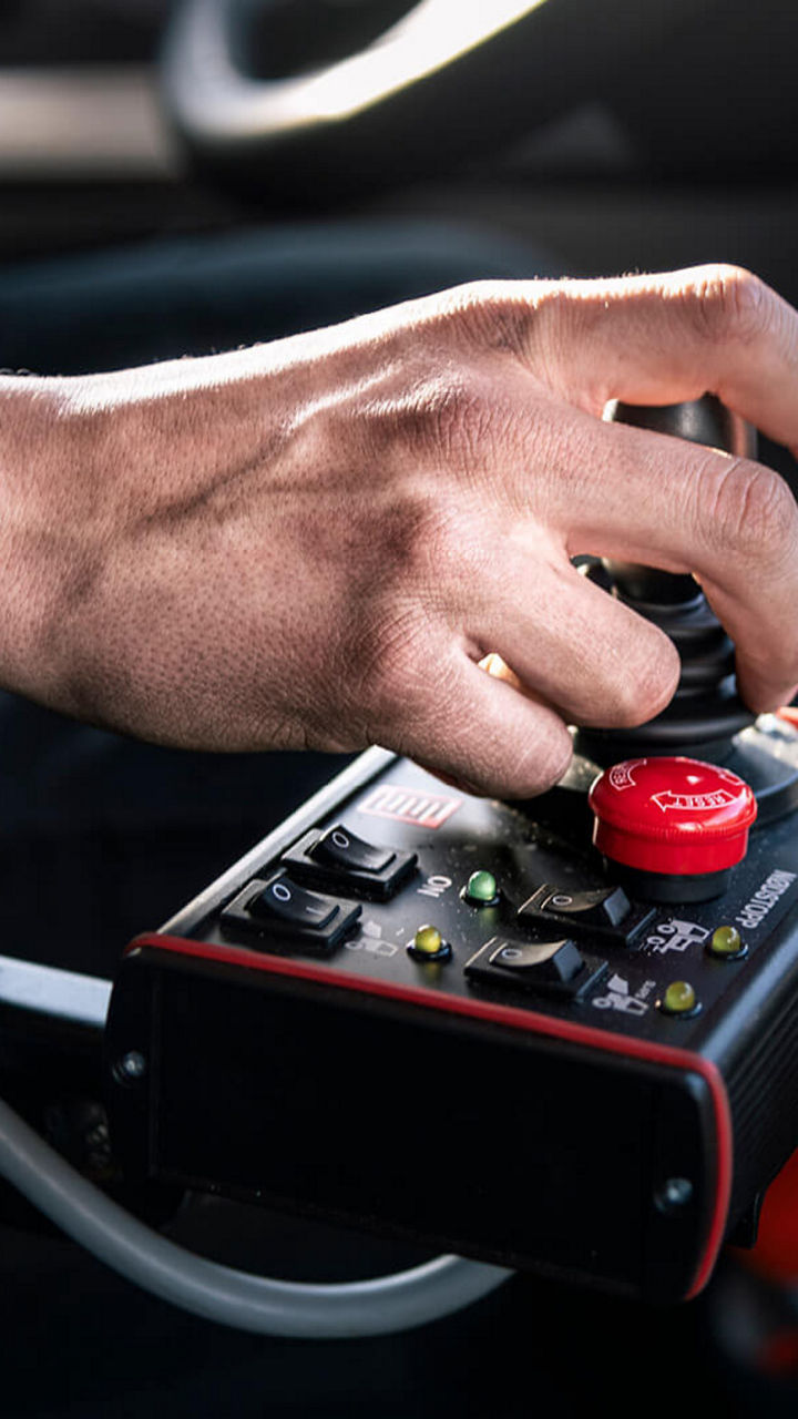 Die Hand eines Lkw-Fahrers am Schalter eines MAN TGS