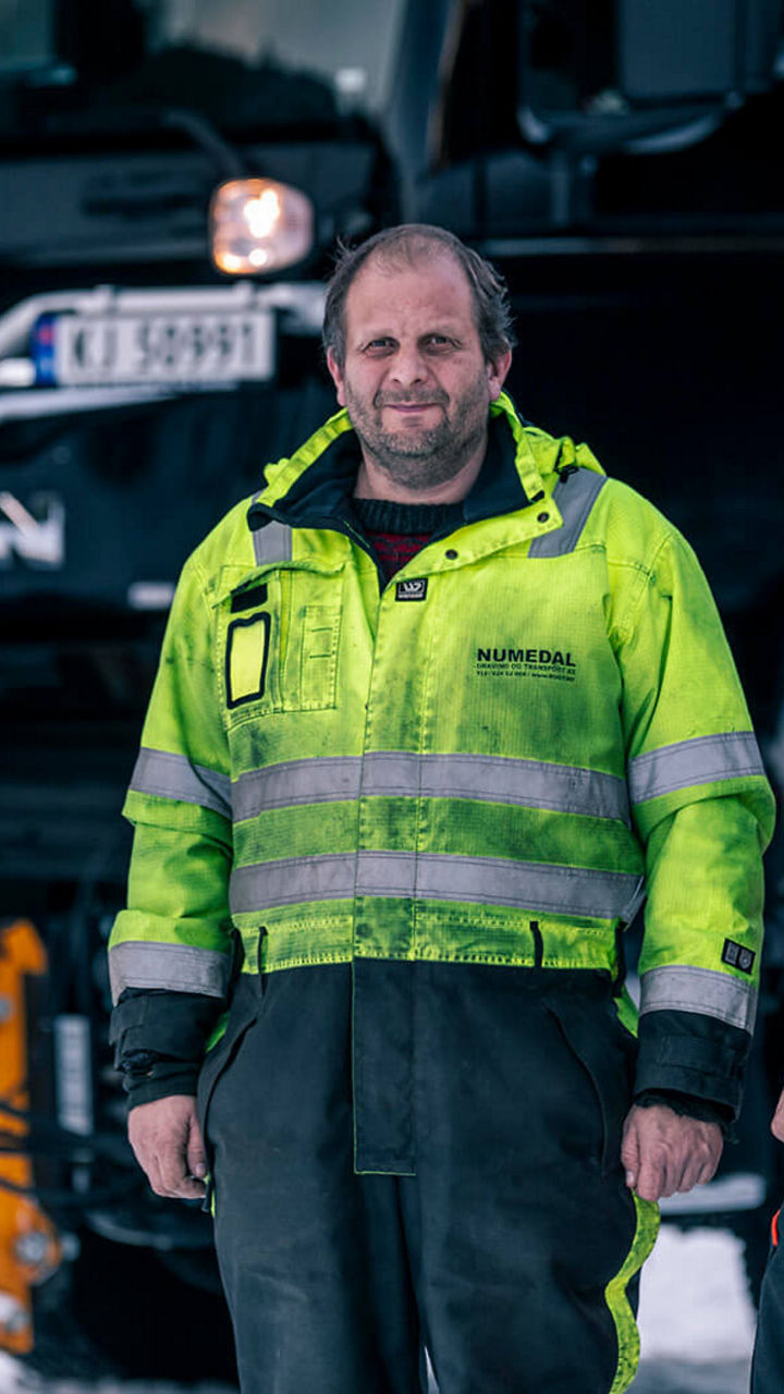 Zwei Männer stehen vor zwei schwarzen MAN TGS