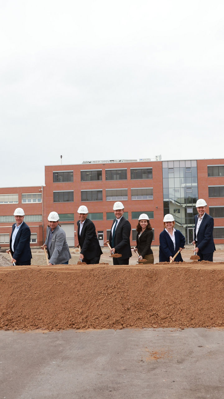 The project leaders take the first groundbreaking and stand in front of a pile of soil
