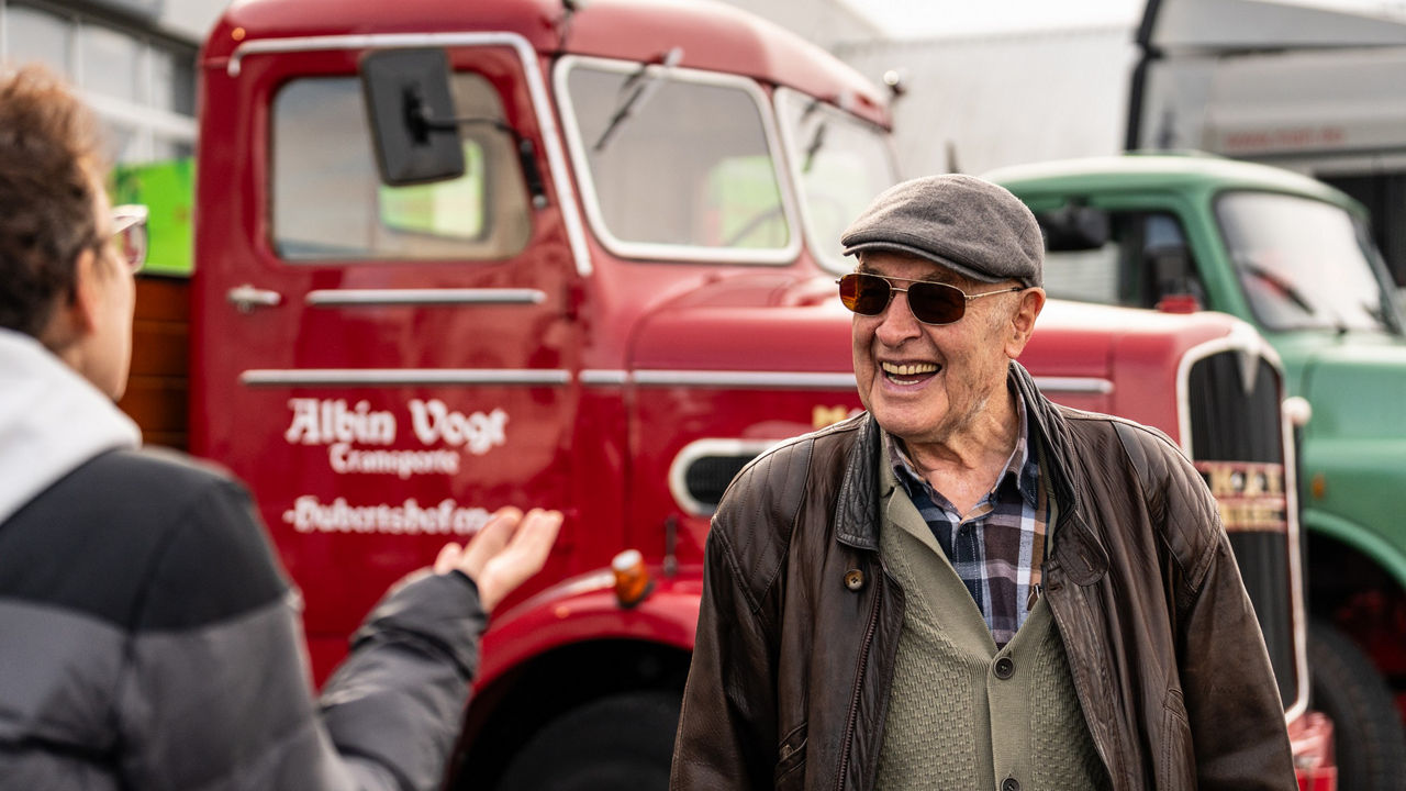Kurt Bantle vor einem MAN Oldtimer im Gespräch mit einer MAN Mitarbeiterin.