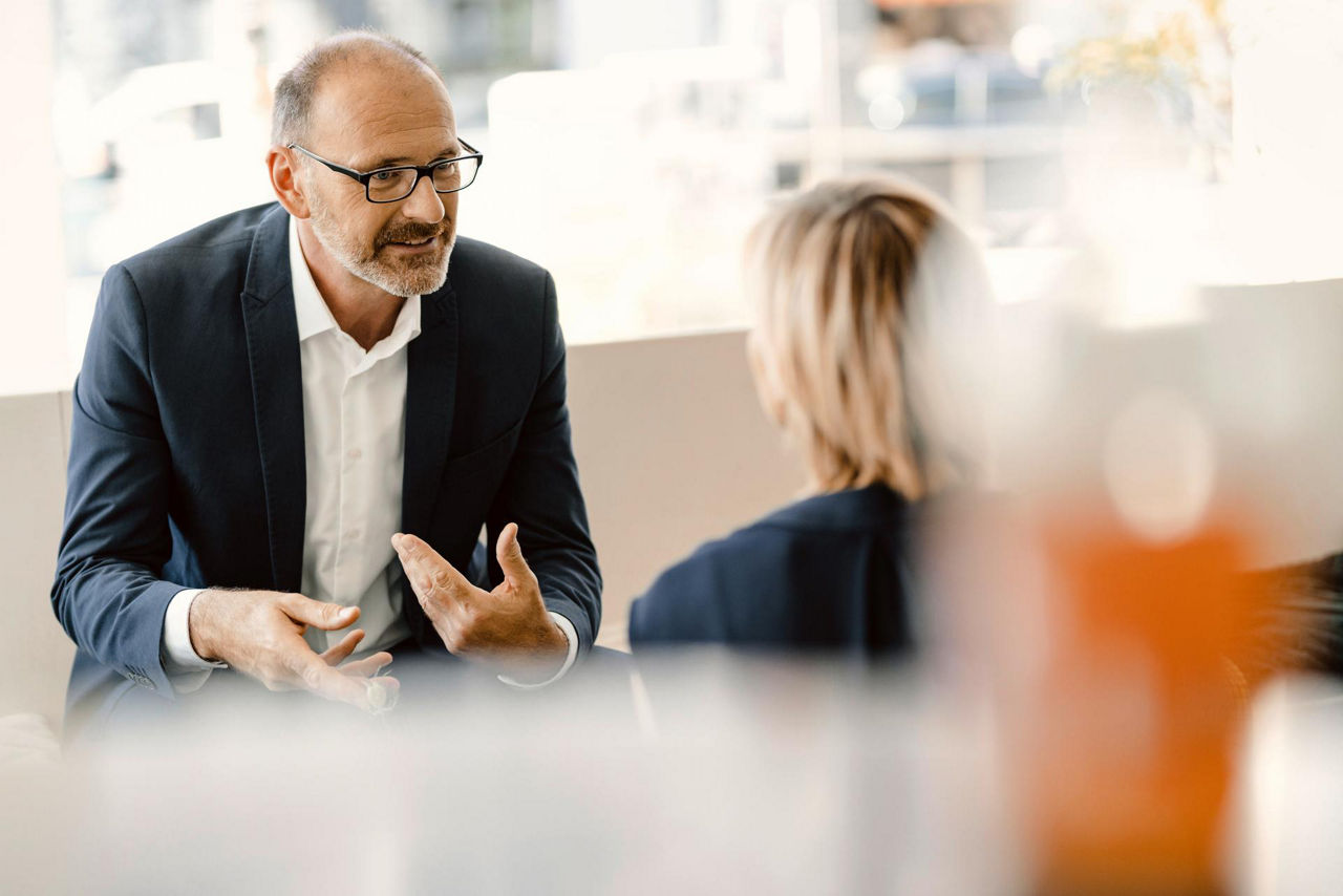 Business conversation between man and woman in modern office