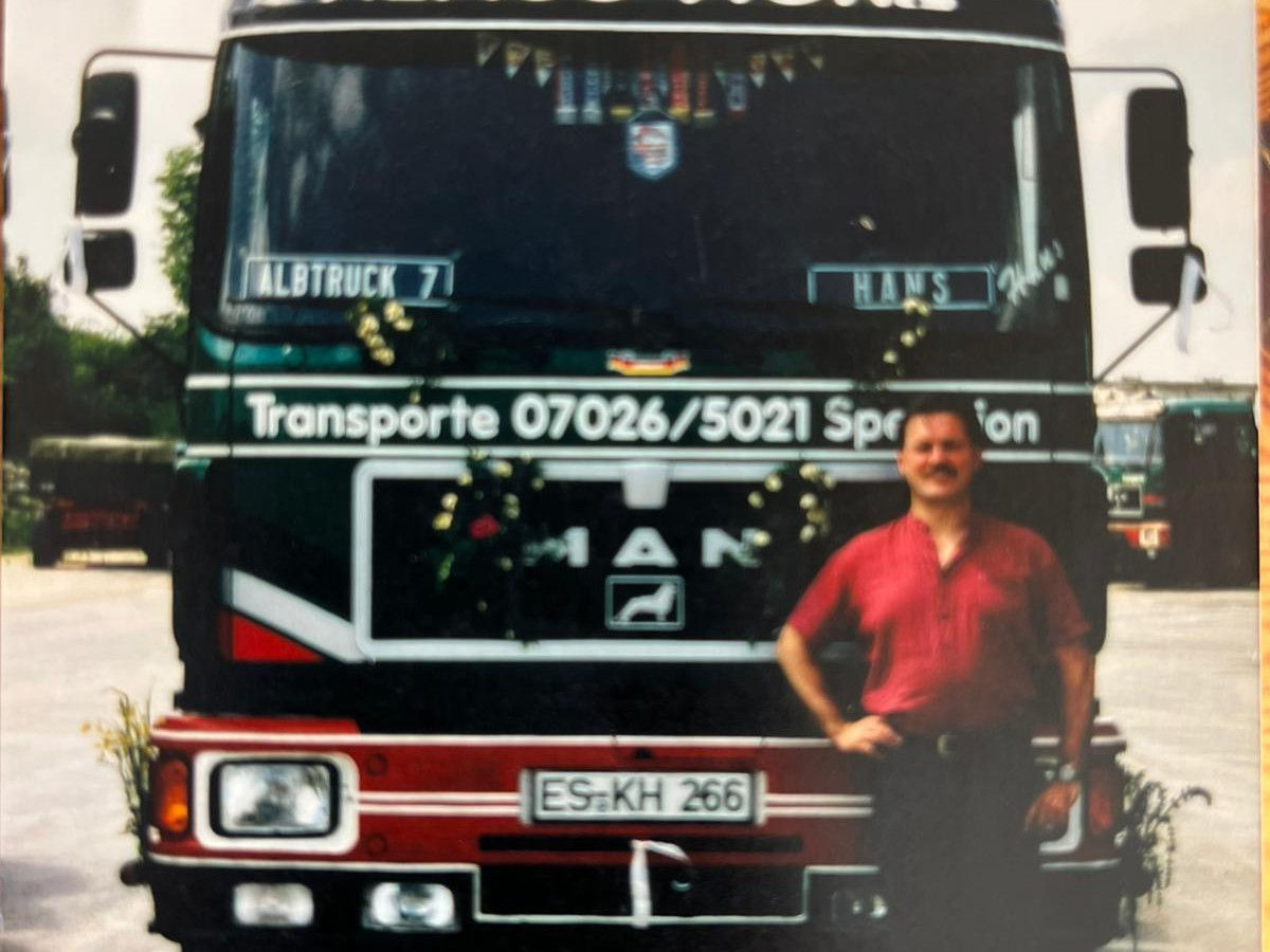 Altes Bild von einem Mann vor altem MAN Lkw