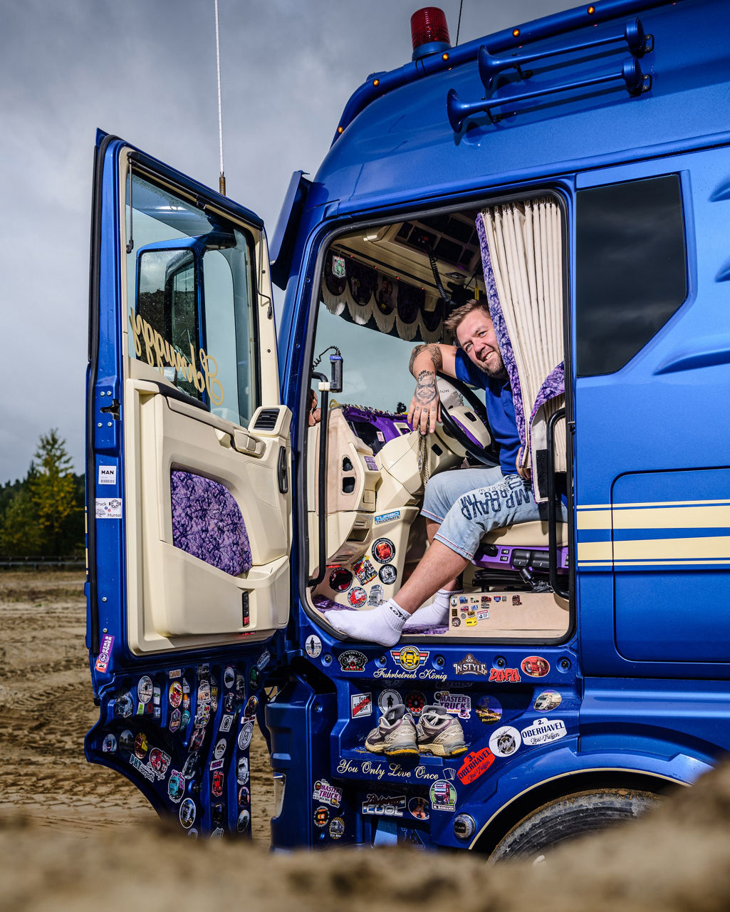 René sitzt auf den Fahrersitz und man bekommt einen Blick in das detailliert gestaltete MAN Lkw-Fahrerhaus.