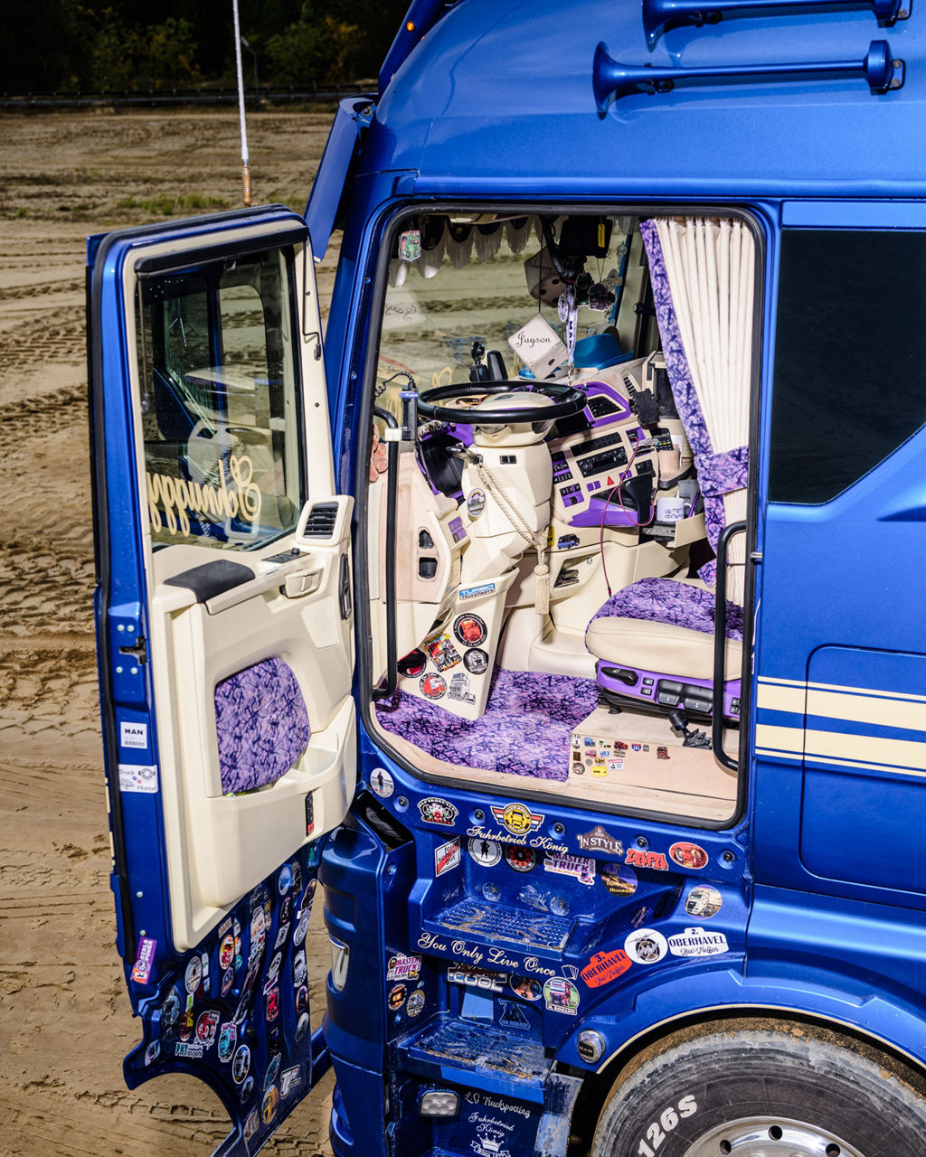Die Fahrertür ist offen und man bekommt einen Blick in das detailliert gestaltete MAN Lkw-Fahrerhaus.