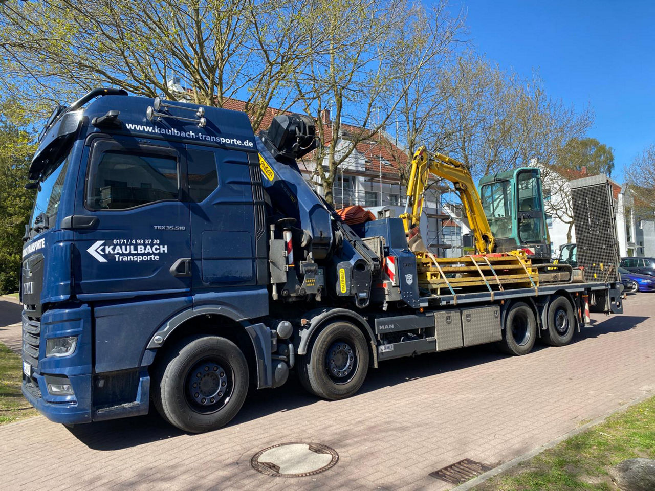 Der blaue MAN TGX von Michael Kaulbach hat einen Minibagger und weiteres Baustellenmaterial geladen.