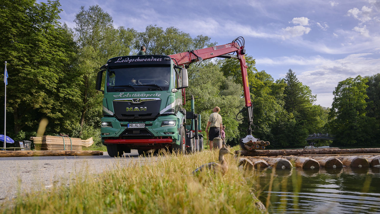 Der grüne MAN lädt das Holz direkt ins Wasser ab damit ein Floss gebaut werden kann.