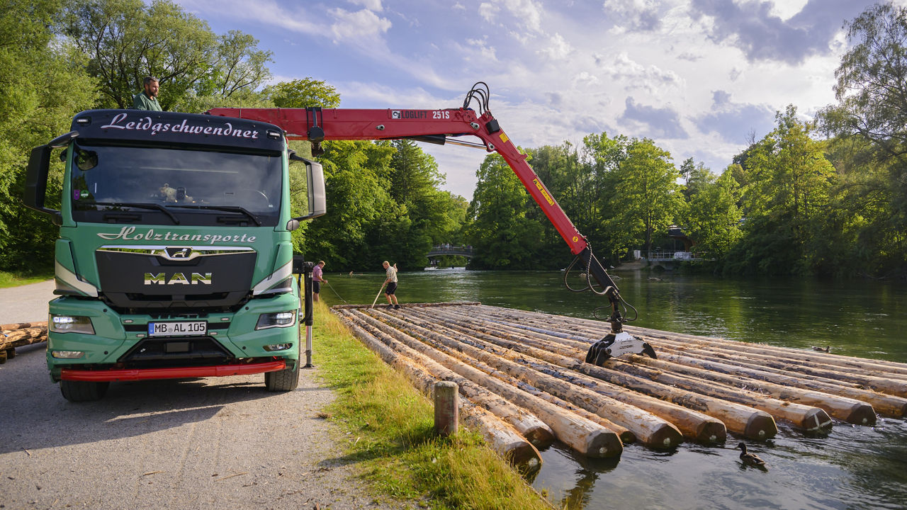 Der grüne MAN lädt das Holz direkt ins Wasser ab damit ein Floss gebaut werden kann.