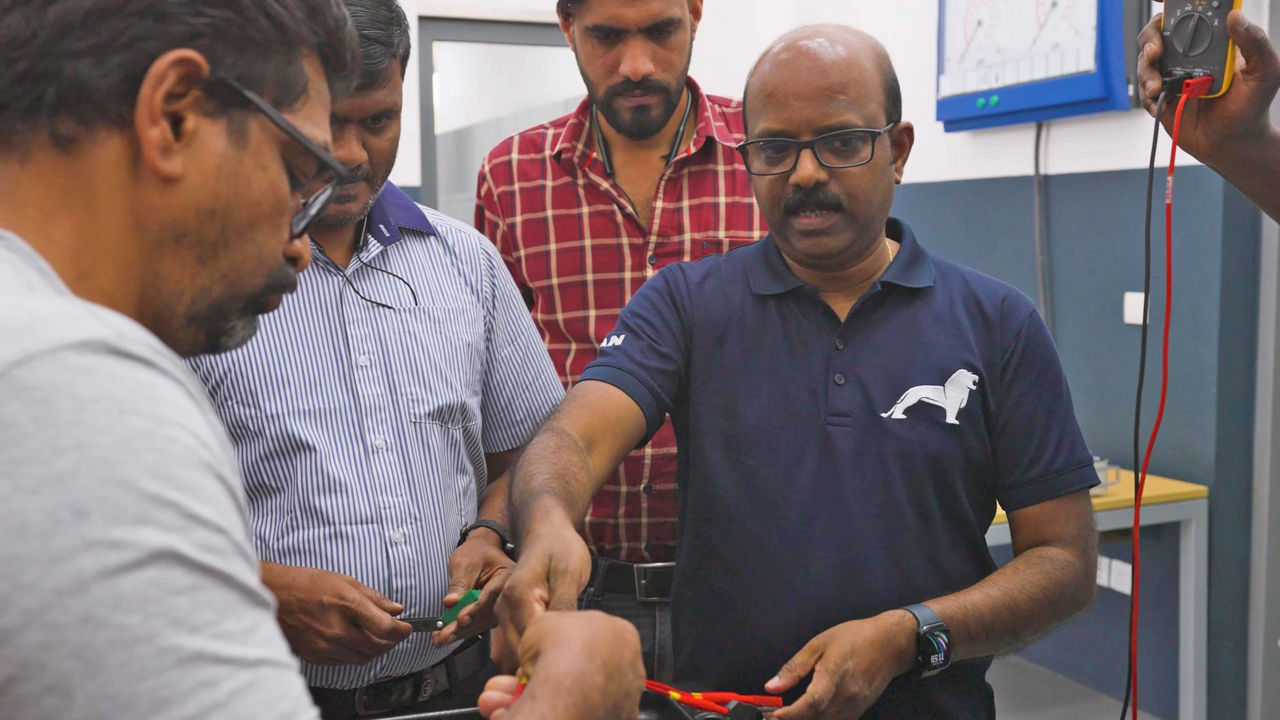 A man explains something to a group of other employees.
