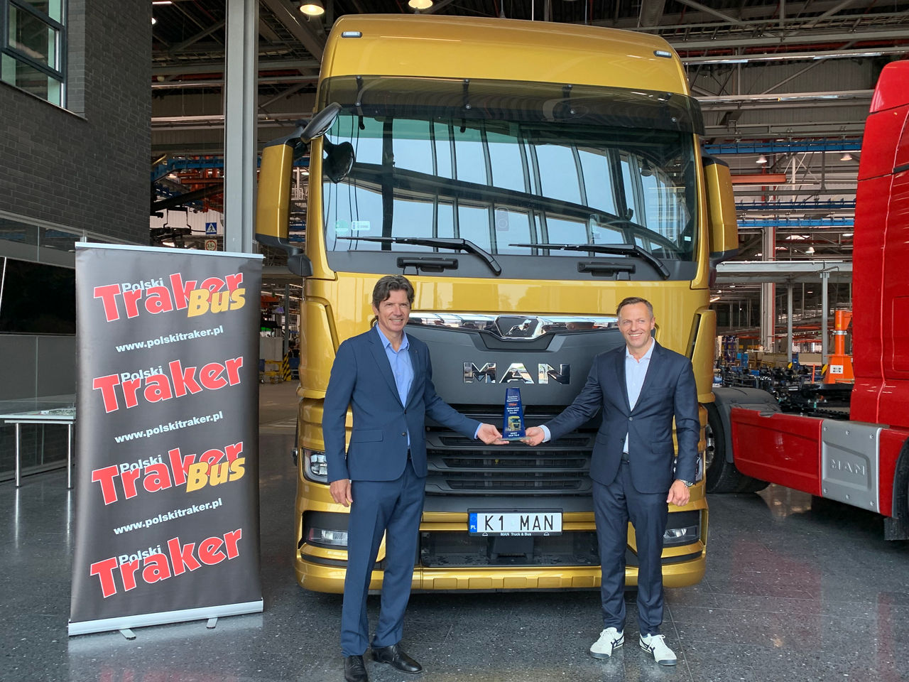 Marc Martinez, prezes MAN Truck & Bus Polska oraz Bernard Wieruszewski dyrektor ds. produktu i sprzedaży ciężarówek odbierają nagrodę w fabryce w Niepołomicach.