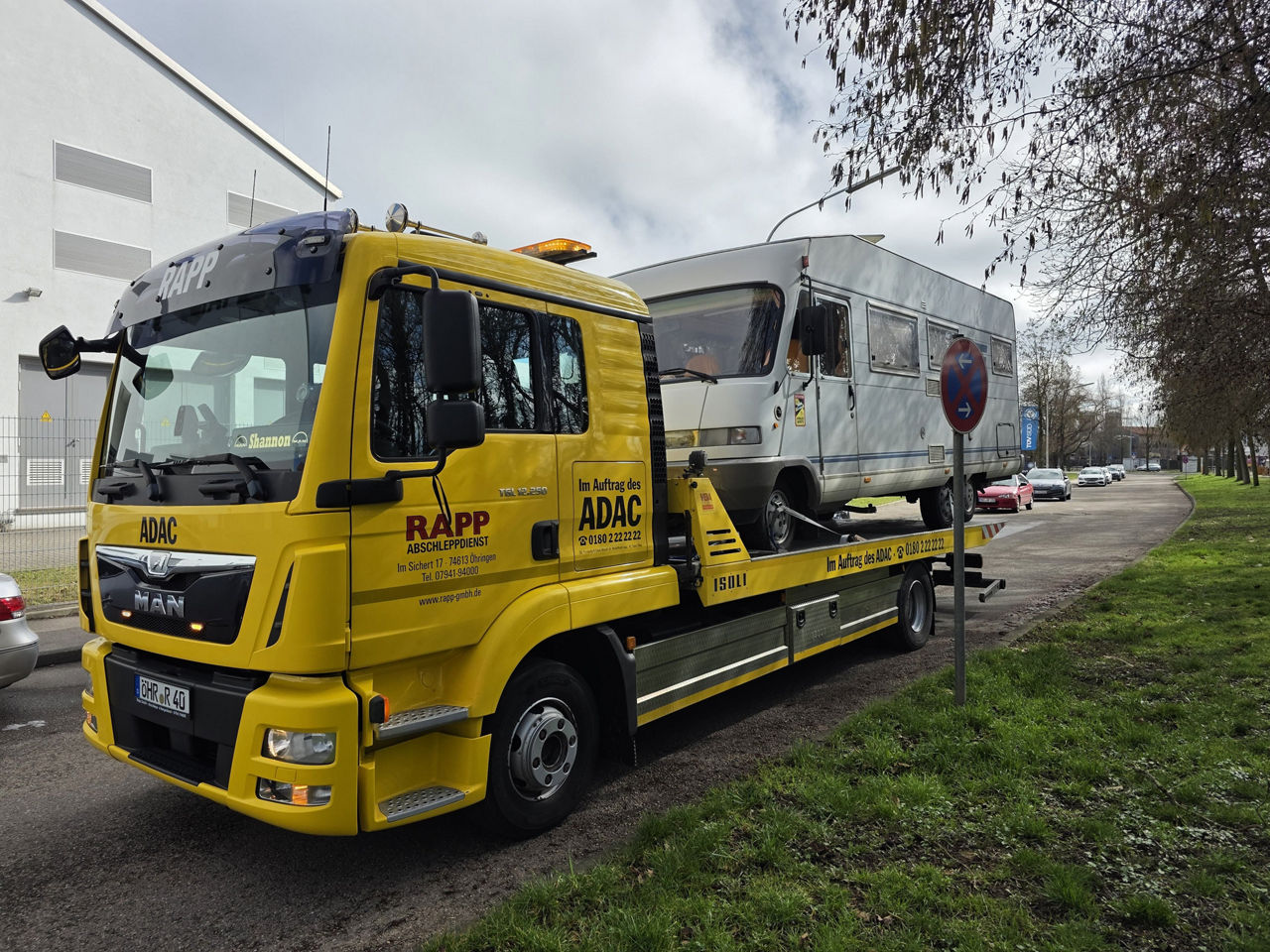 Gelber MAN Lkw mit einem Camper auf dem Sattel