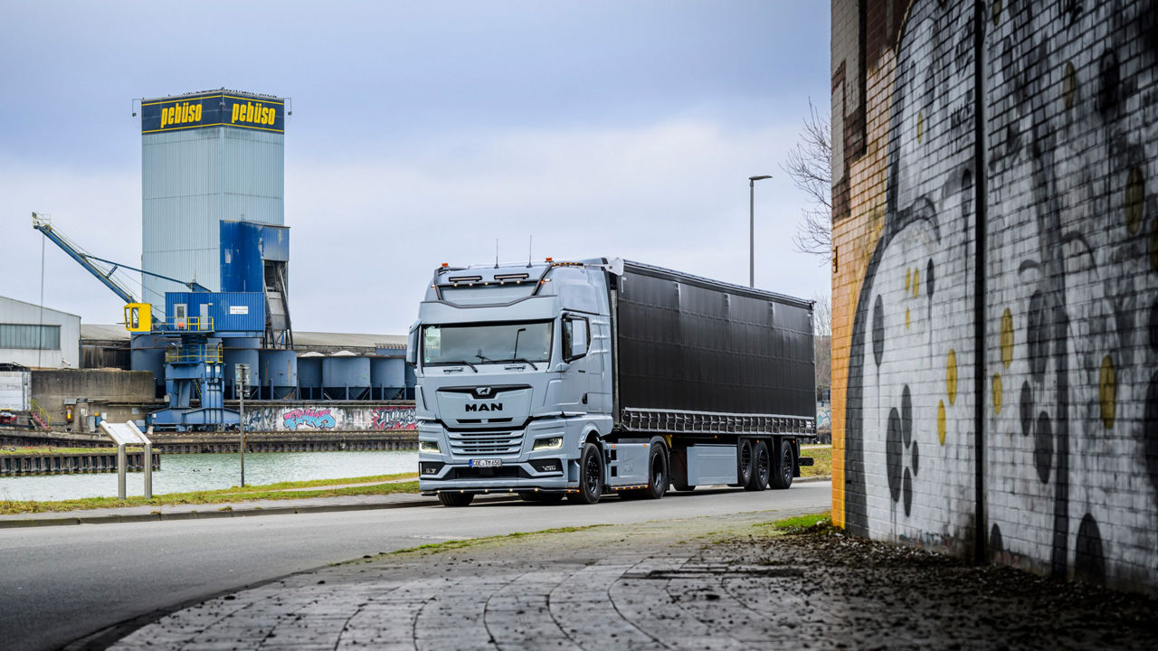 Ein grauer MAN TGX 18.560 mit D30-Motor fährt unter eine Unterführung mit Airbrush an den Wänden