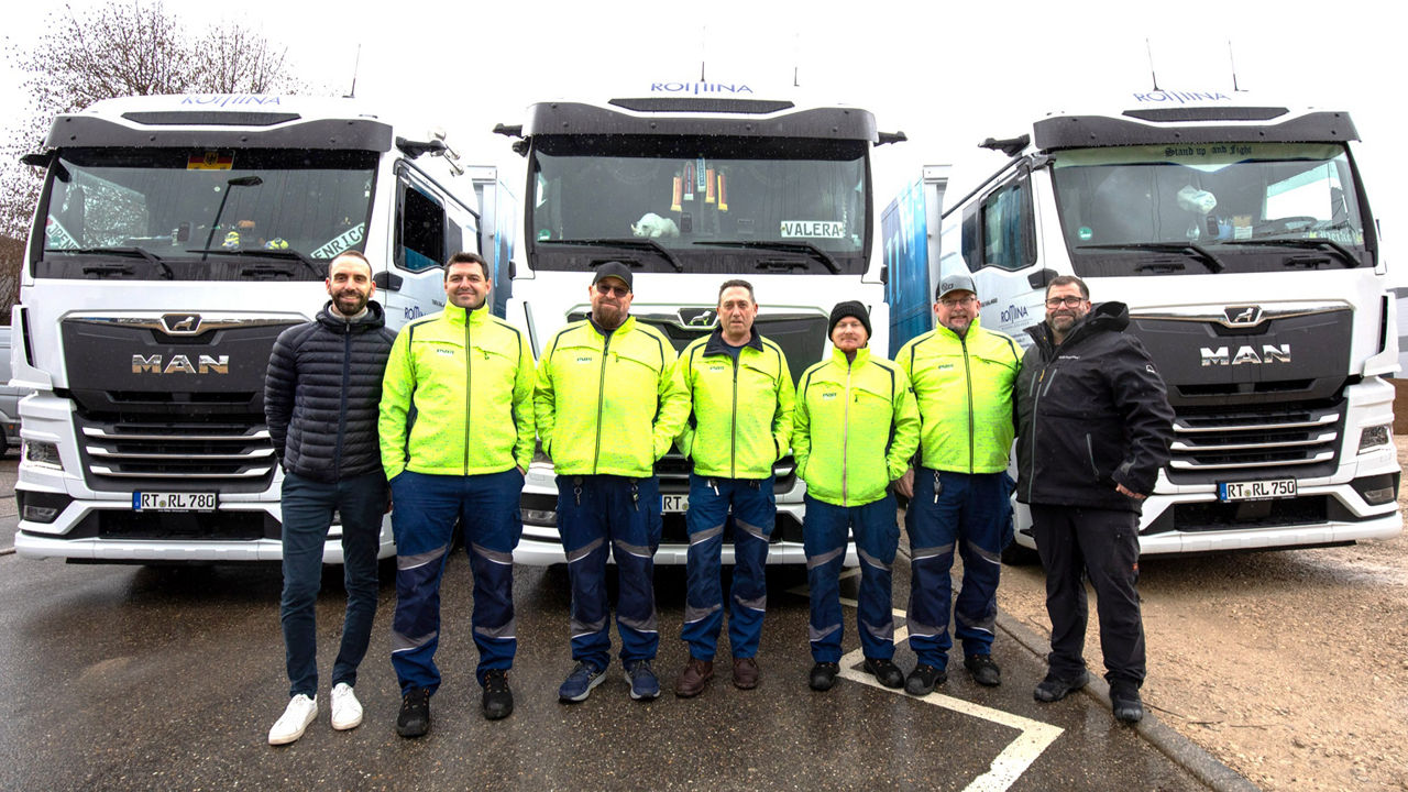 Männer mit gelben Jacken vor MAN Lkws