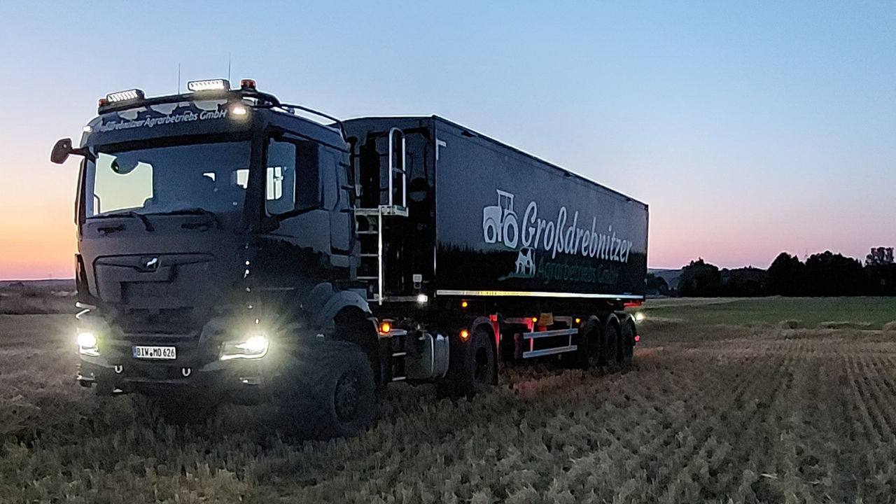 Feldeinsatz eines schwarzen MAN-Lkw bei Nacht.