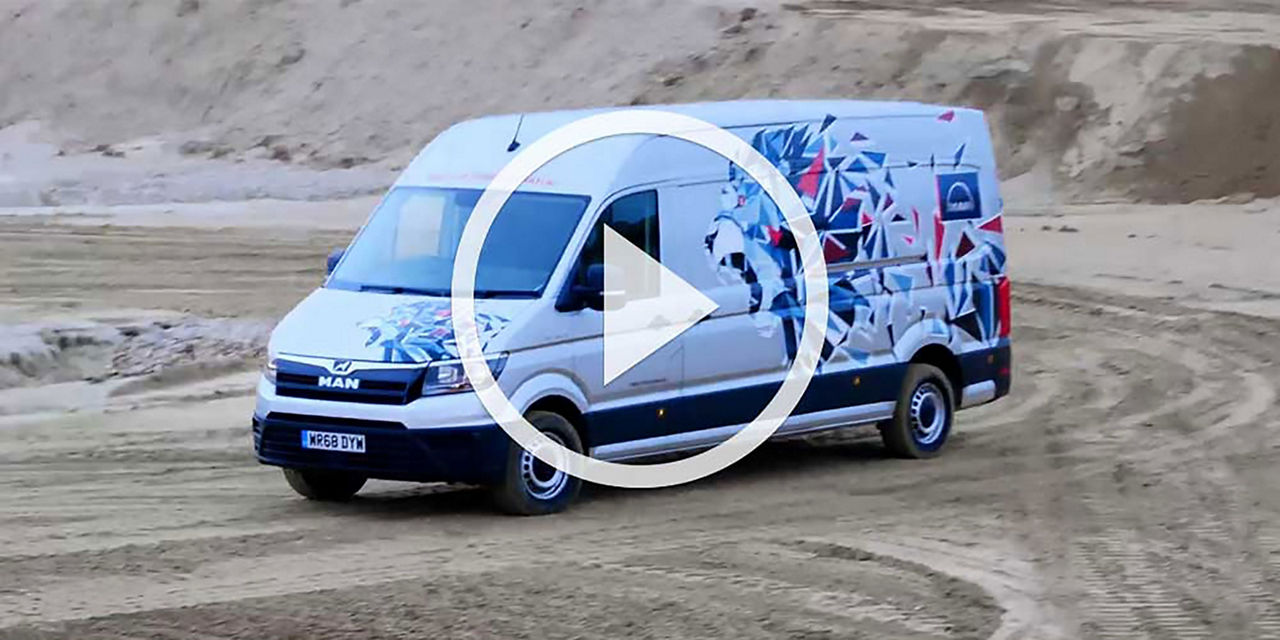 Video still of a MAN TGE van with graphic wrap driving in sand