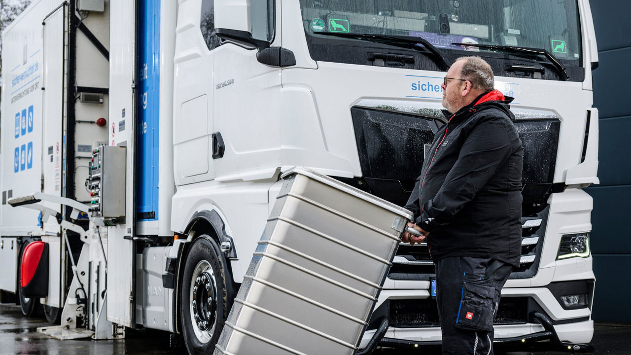 Die Datenmülltonne wird zum weißen MAN TGX gefahren wo daraufhin die Datenträger geschreddert werden.