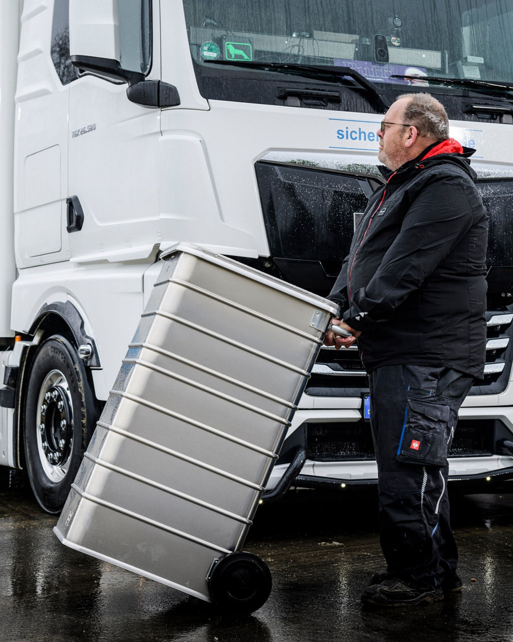Die Datenmülltonne wird zum weißen MAN TGX gefahren wo daraufhin die Datenträger geschreddert werden.