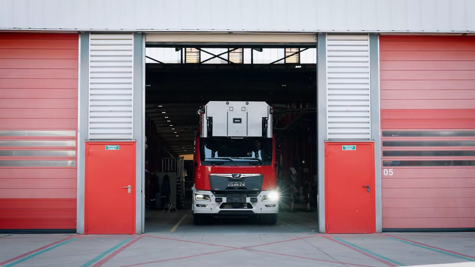 Firetruck Rosenbauer eTGM is driving out of the garage