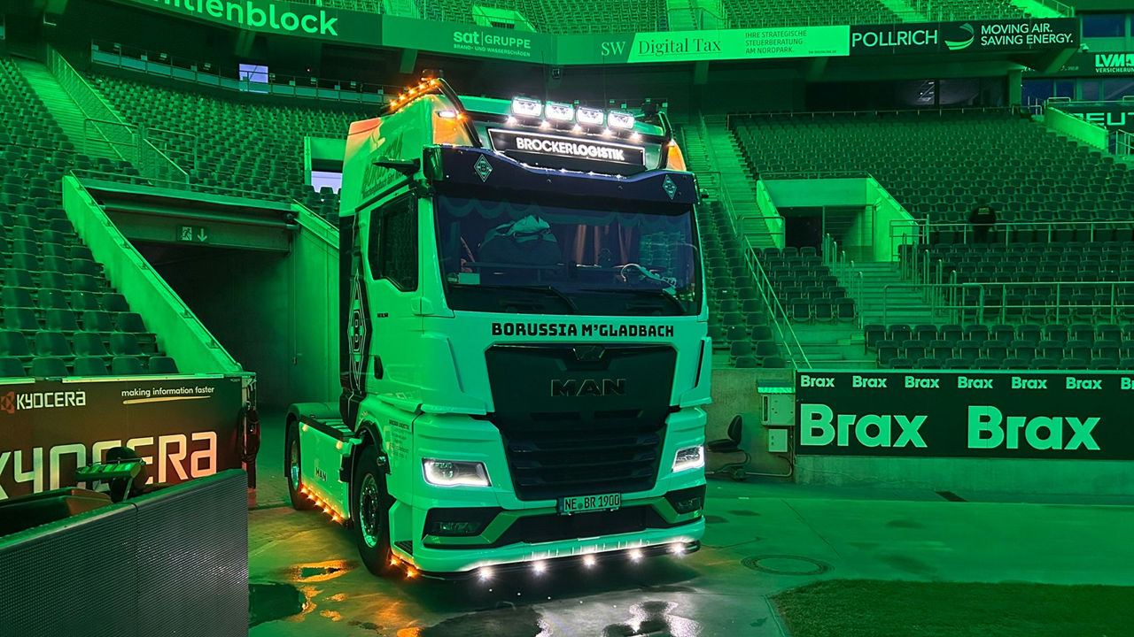 Ein weißer MAN TGX mit Borussia Mönchengladbach Beklebung und grüner Beleuchtung im Hintergrund im Stadion von Borussia Mönchengladbach.