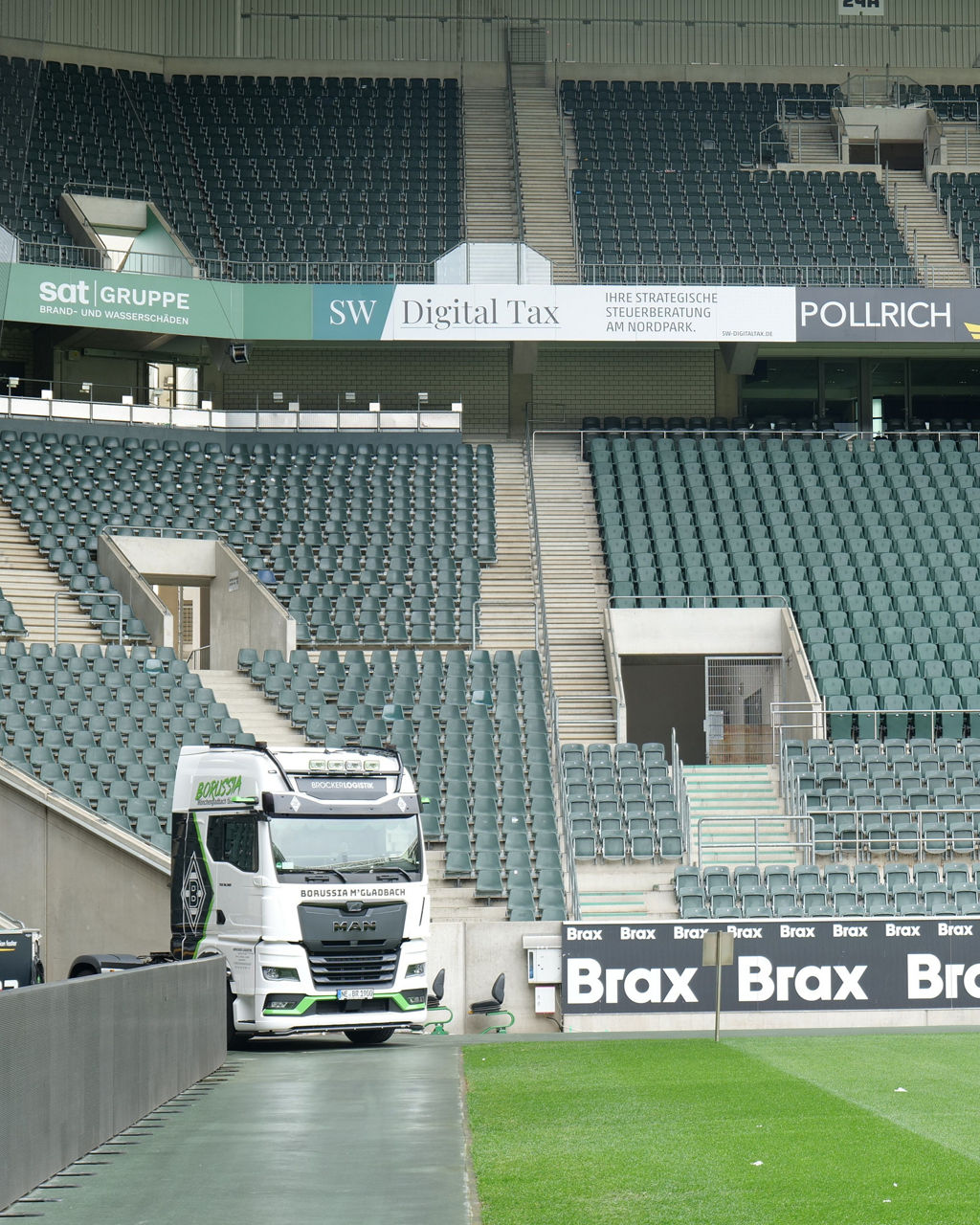 Ein weißer MAN TGX mit Borussia Mönchengladbach Beklebung und im Stadion von Borussia Mönchengladbach. Im Hintergrund sieht man die Ränge und Sitzplätze.
