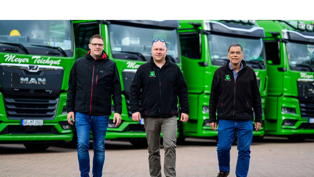 3 Männer vor grünen MAN TGX