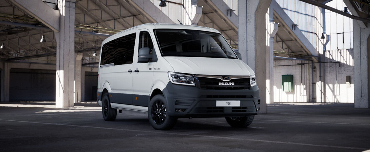 Side view of a white MAN high-roof delivery van in a large indoor hall