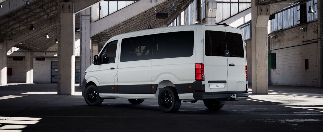 Full lright-side profile of a white MAN panel van in an industrial building