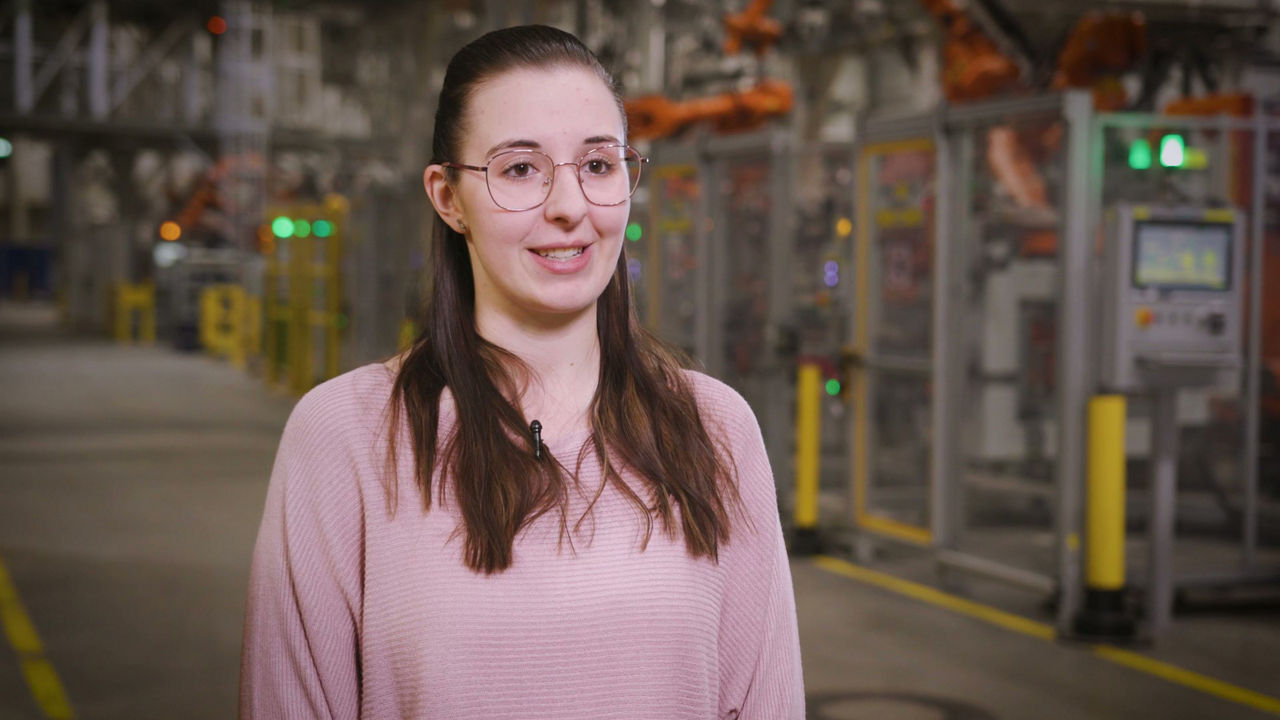 A woman with glasses is looking at the camera