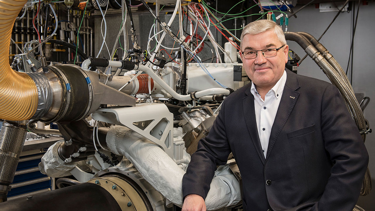 Head of Development Werner Kübler in front of a stationary hydrogen combustion engine