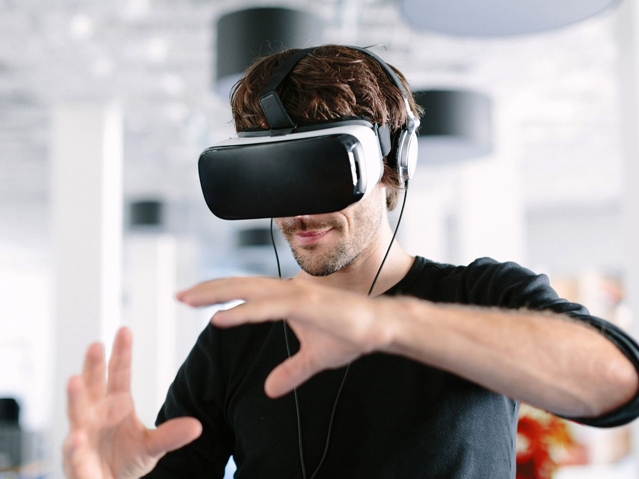 a man wears VR glasses and gestures