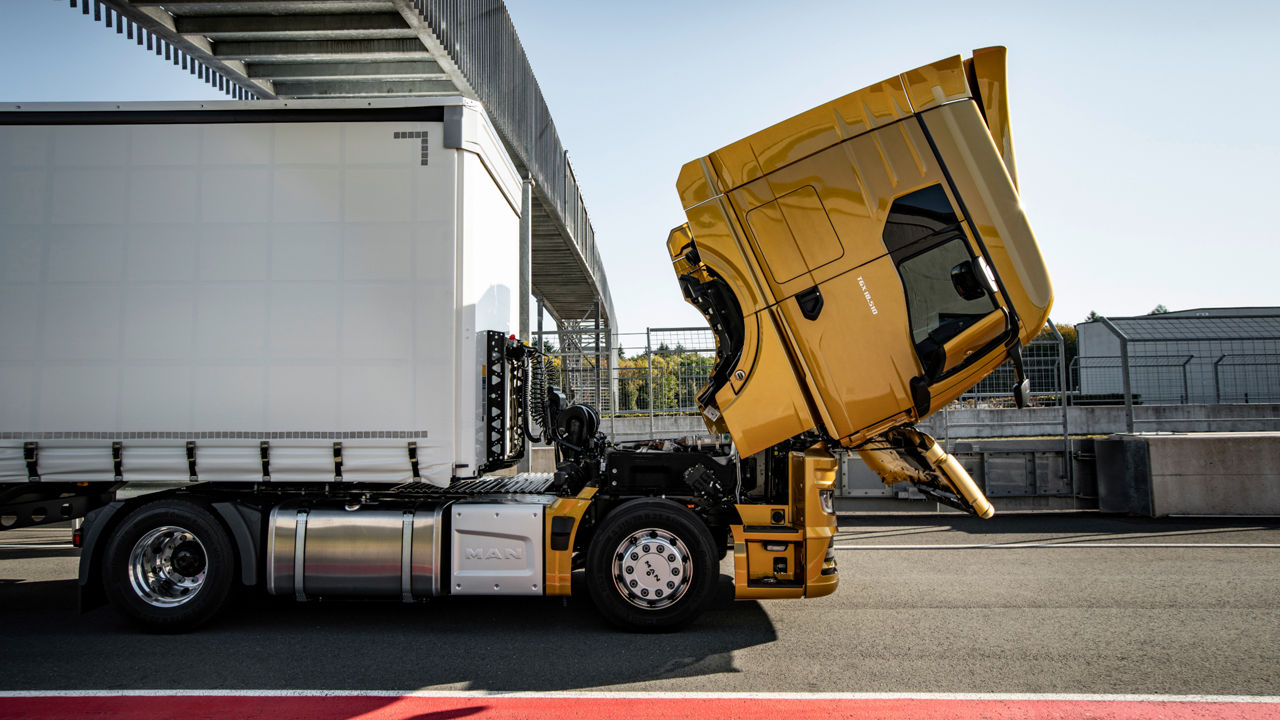 Gelber MAN TGX mit aufgeklapptem Fahrerhaus