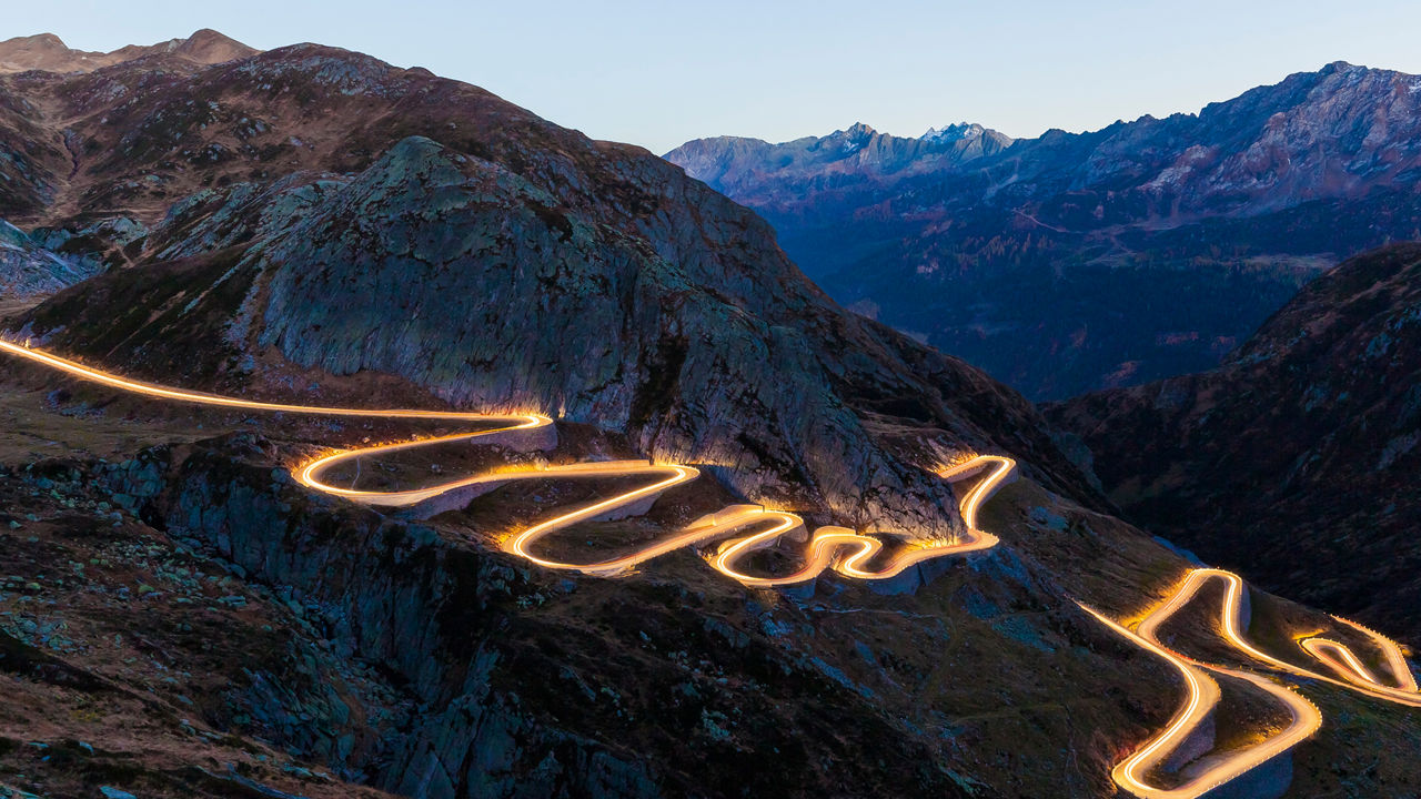 Illuminated road winding its way up in serpentines.