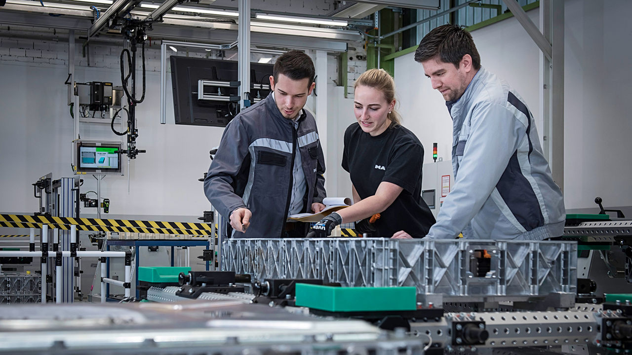 MAN employees in production look at something